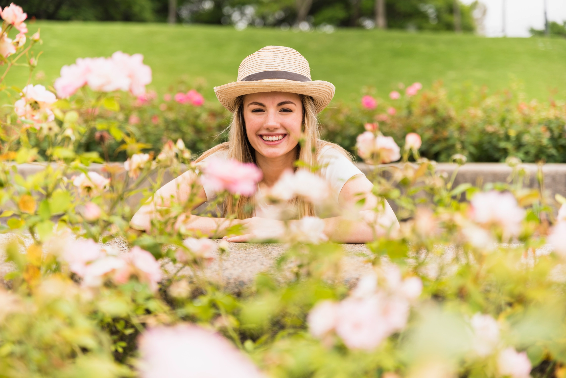 cheerful-lady-hat-near-white-blooms-park