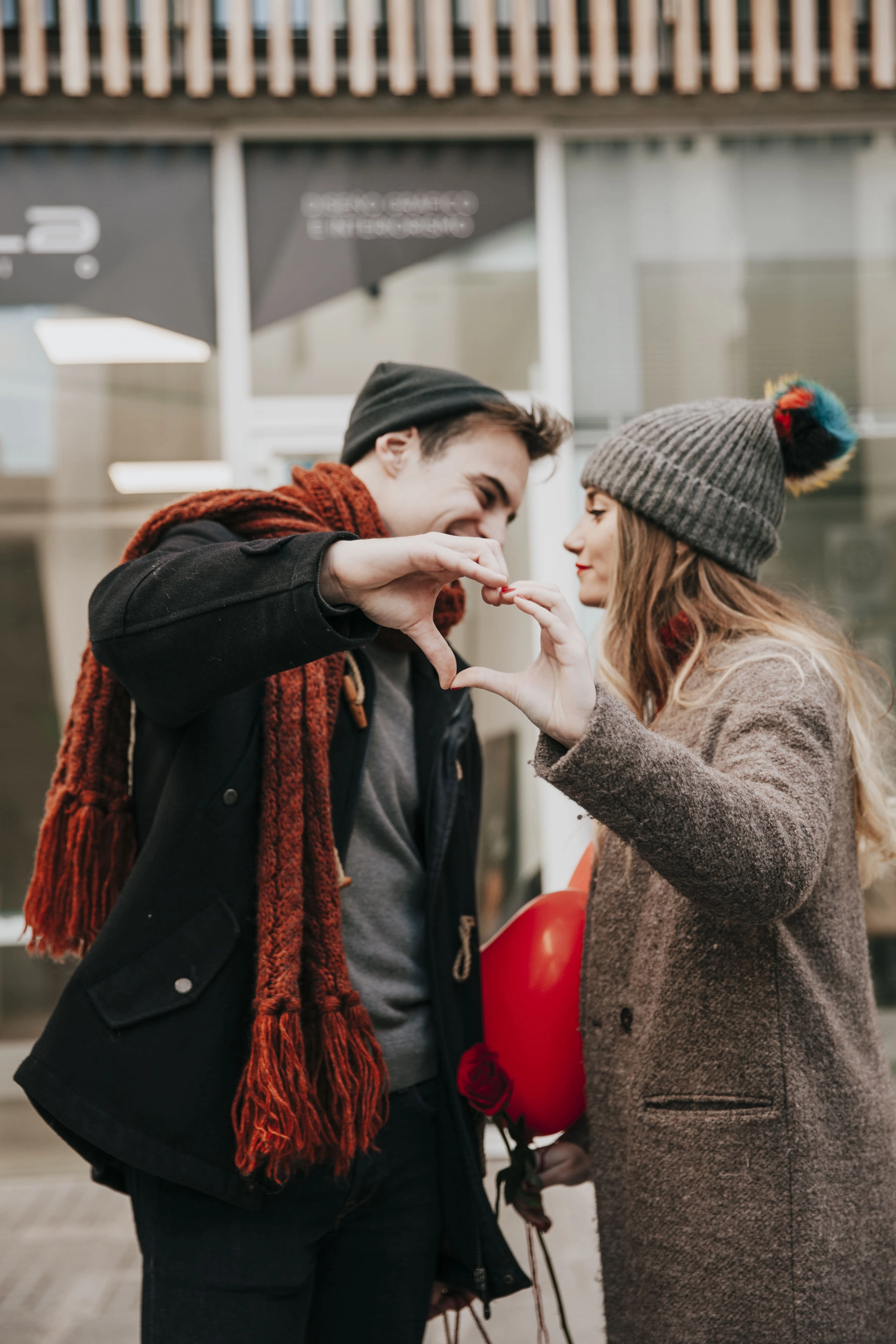 couple-showing-heart-gesture-before-kiss