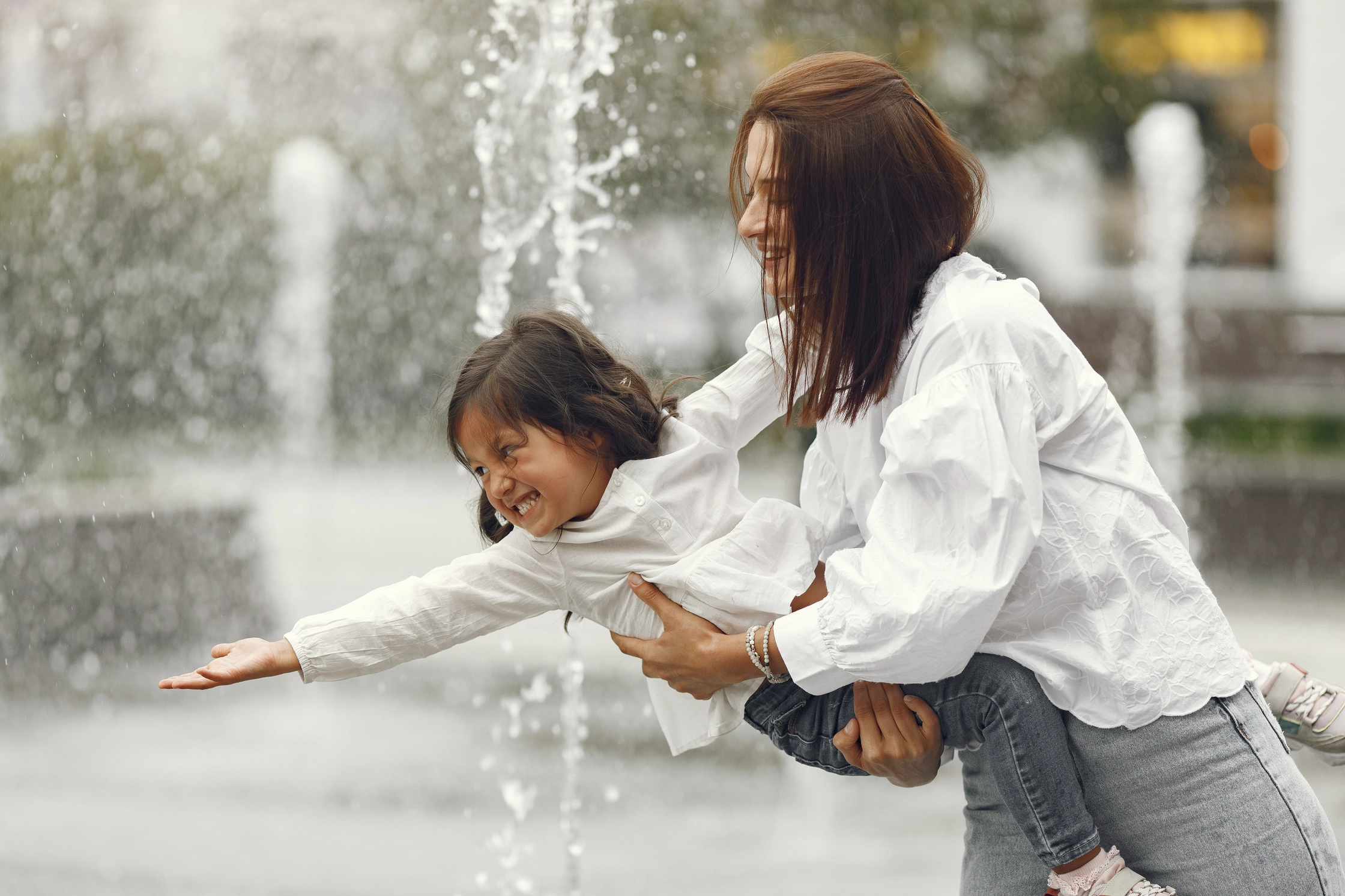 family-near-city-fountain-mother-with-gaughter-playing-with-water (1)