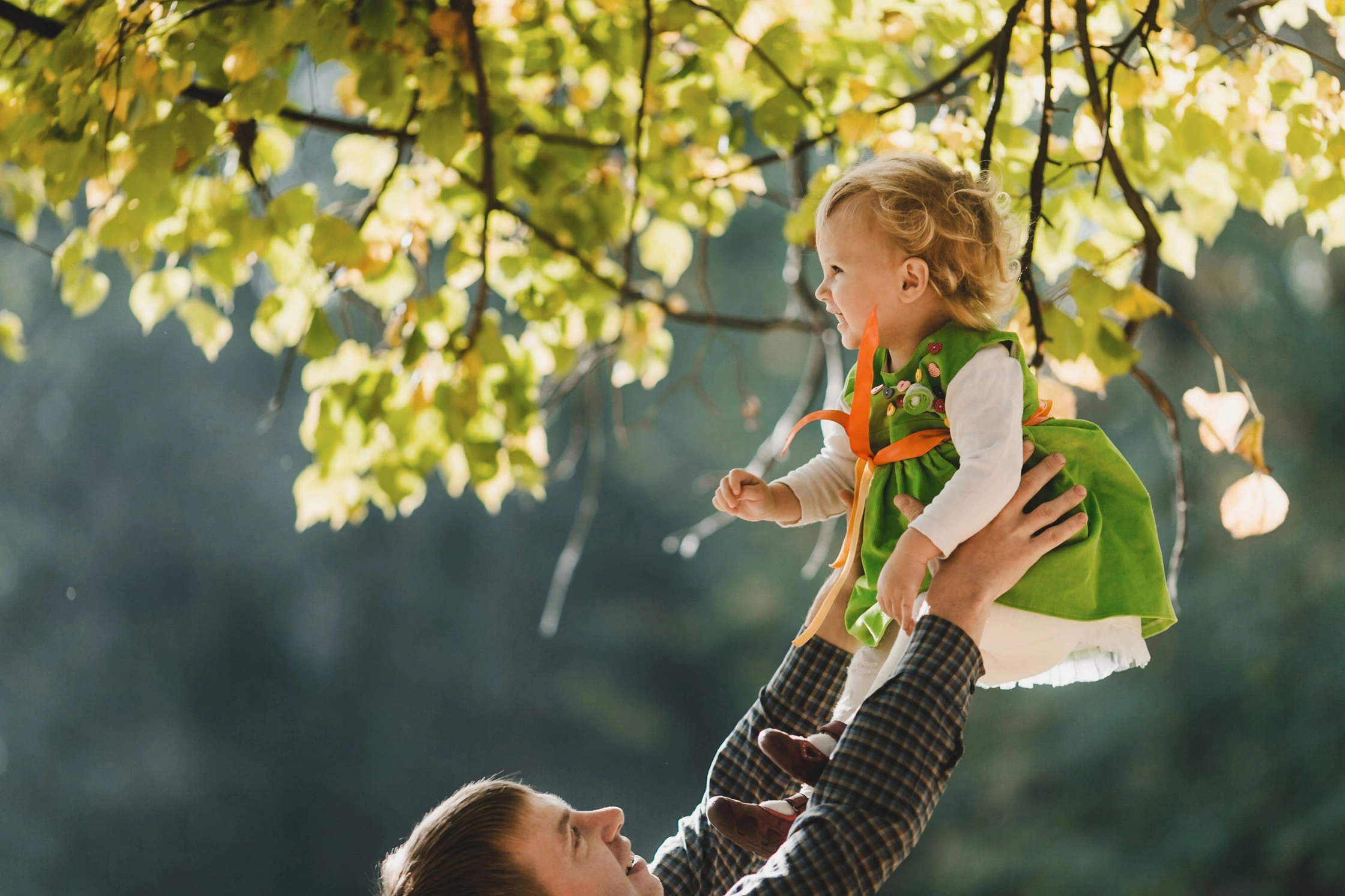 father-holds-hands-his-daughter-park