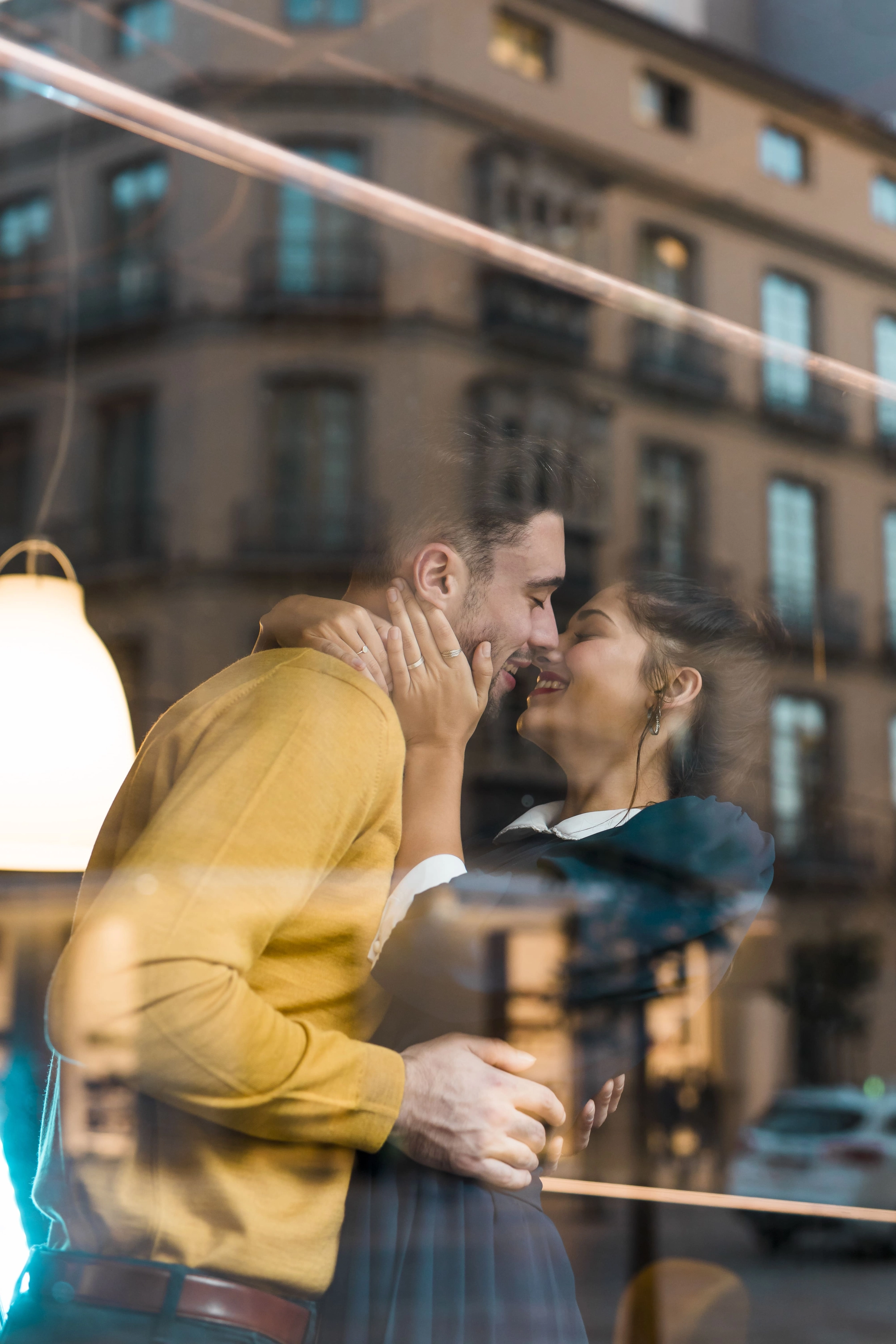 man-hugging-with-happy-woman-near-window-restaurant