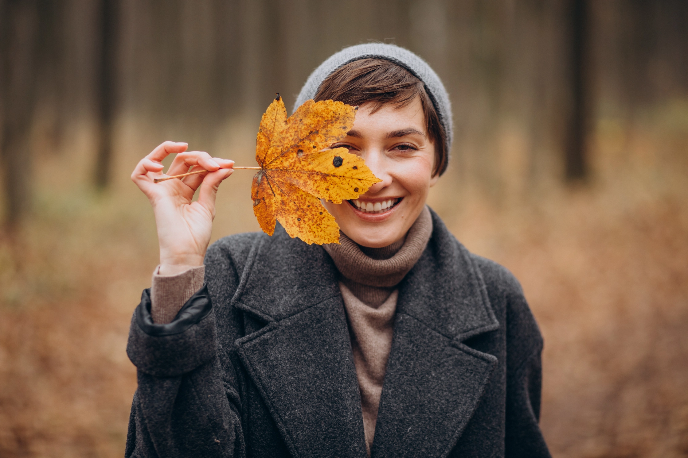 young-woman-autumn-park-holding-leaf-by-face